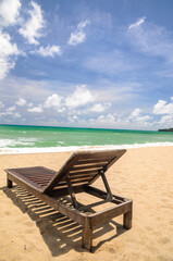 Fototapeta na wymiar The beach chairs on sandy beach with cloudy blue sky and sun in the summer