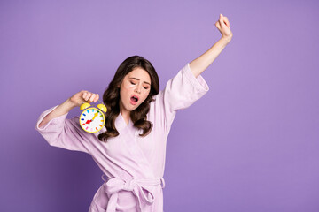 Photo of young sleepy woman yawn use under eye patch hold clock isolated over purple color background