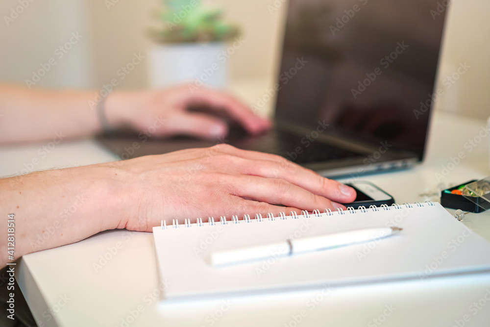 Sticker a male programmer works in front of a laptop screen in a bright office or remotely from home. workpl