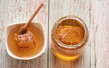 jar of liquid honey with honeycomb