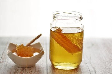 jar of liquid honey with honeycomb
