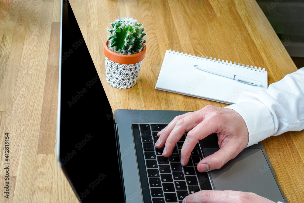 Sticker a male programmer works in front of a laptop screen in a bright office or remotely from home. workpl