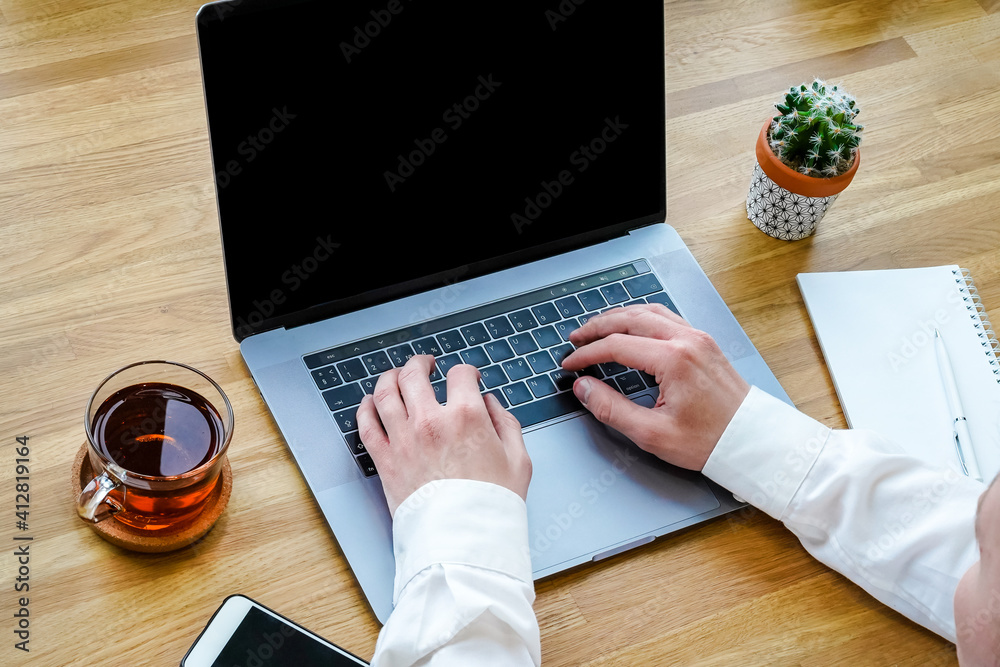 Poster a male programmer works in front of a laptop screen in a bright office or remotely from home. workpl