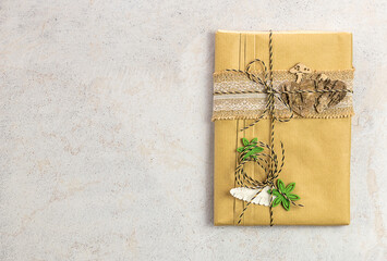 Book wrapped in craft paper with wooden decorations. Zero waste, eco friendly packaging gift.