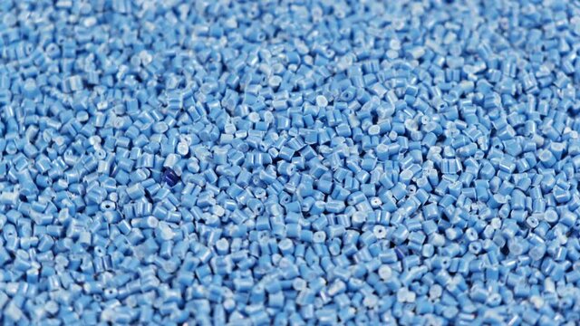 Secondary granule made of polypropylene, Blue Plastic pellets crumbles to the table . Plastic raw materials in granules for industry. Polymer resin. Raw plastic recycling concept