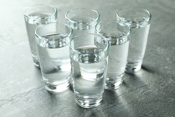 Shots with vodka on gray background, close up