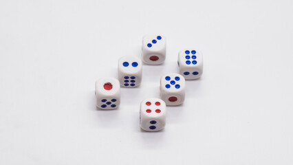 Heap of white cubic six dices with blue and red spikes (dots) on a white background. Game, gambling, chance and risk concept