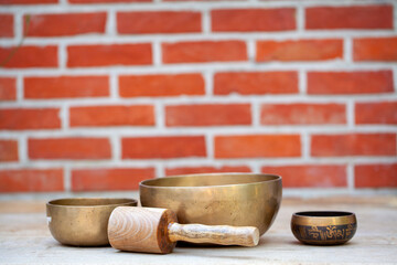Tibetan singing bowls with sticks on the wall background - music instruments for meditation, relaxation after yoga practice and healing massage. High quality photo