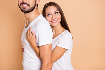 Cropped photo of pretty adorable husband wife wear white t-shirts embracing smiling isolated beige color background