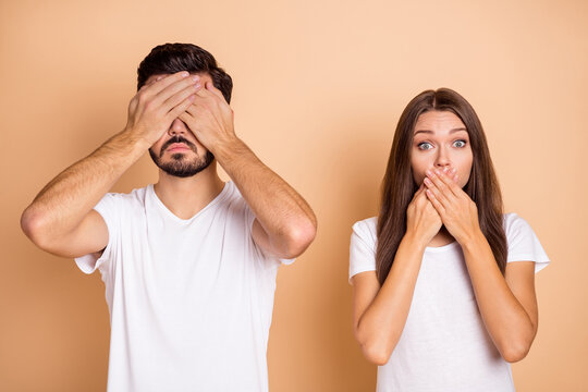Photo of young couple man close eyes woman cover lips afraid nervous panic fail mistake isolated over beige color background