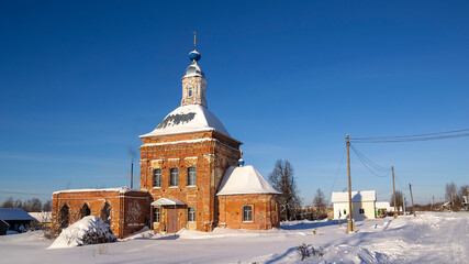 red brick village church in winter