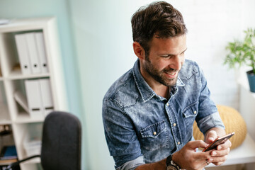 Fototapeta premium Businessman in office using the phone. Young businessman working in the office.