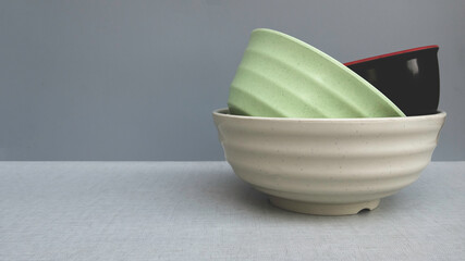 A stack of colorful bowl on grey background with copy space.
