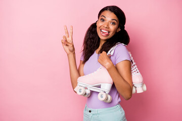 Profile side view portrait of lovely funny cheerful girl carrying rollers showing v-sign isolated over pink pastel color background © deagreez