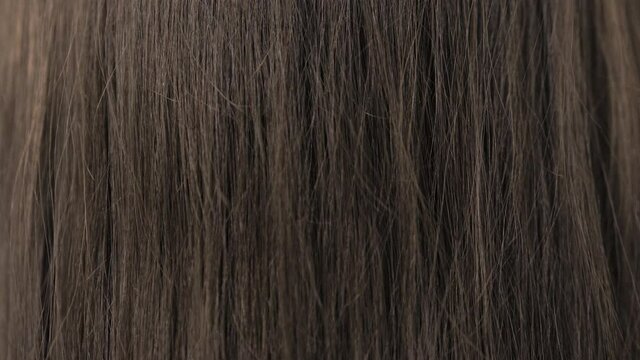 Demonstration of the brunette's hair before straightening it. Brittle tangled brunette hair. High quality 4k footage. Close-up