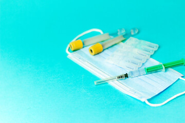 Medical vials for injection, syringe for injection, mask gloves on a blue background. Admission vaccination, flu shot.