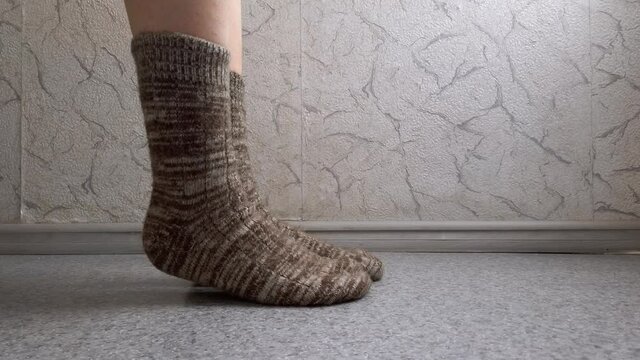The girl in woolen socks moves her legs.