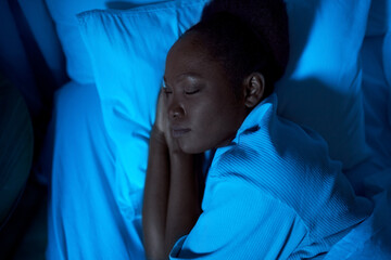 people, relax and comfort concept - young african american woman sleeping in bed at home at night