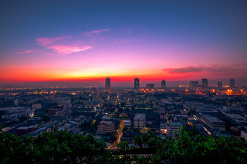 The high angle background of the city view with the secret light of the evening, blurring of night lights, showing the distribution of condominiums, dense homes in the capital community