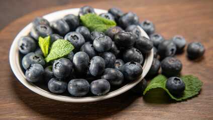 Blueberries on a plate on a wooden background