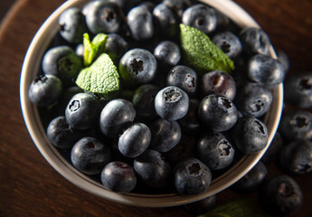 Blueberries on a plate on a wooden background