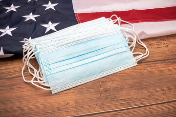 Protective face mask on American flag on wooden background , Concept to protect coronavirus covid-19 epidemic in America