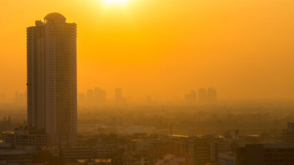 The blurred abstract background of the morning sun exposure to the tiny dust particles that surround the tall buildings in the capital, the long-term health issue of pollution