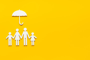 Wooden family figure under umbrella with space for text. Insurance concept