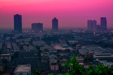 Fototapeta premium The blurred abstract background of the morning sun exposure to the tiny dust particles that surround the tall buildings in the capital, the long-term health issue of pollution