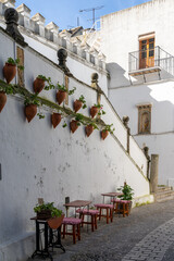 Fototapeta na wymiar Spanish architecture style buildings with whitewashed walls and flower pots on the walls