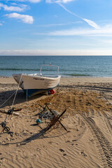Fototapeta na wymiar small wooden fishing boat and anchor on a sandy beach