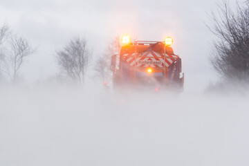 Räumfahrzeug auf schneebedeckter Straße im Winterdienst