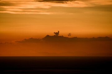 Fototapeta na wymiar great view of clouds in orange sky above the ocean horizon line