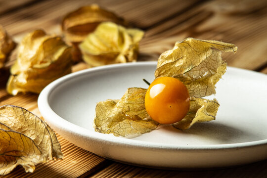 berries and fisalis leaves on a wooden background