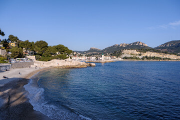 Fototapeta premium Beach and cliffs of Sormiou near Marseille, France. - The typical Mediterranean shoreline of the Calanques region near Marseille. White rocks, blue sky and sea.
