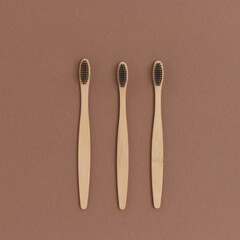 Layout of toothbrushes on a brown background. Plastic free concept.