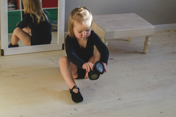 Funny little girl preparing for practicing ballet or dance lessons at home, new normal concept. Little girl dreams of becoming a ballerina