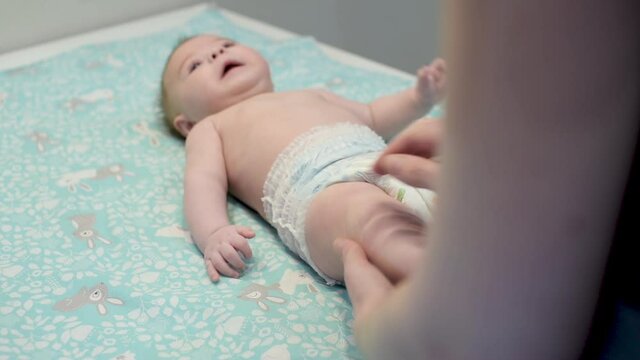Newborn baby development. 3 months baby boy. Mother massaging and tickling small baby legs