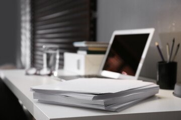 Stack of blank paper on white table in office, closeup. Space for text