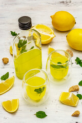 Traditional Italian digestif: liqueur Limoncello with lemons and fragrant mint leaves