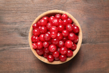 Tasty ripe cranberries on brown wooden table, top view