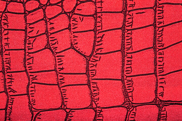 Red alligator patterned background. Genuine crocodile leather pattern.