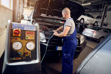 Obraz na płótnie Canvas Mechanic checks air conditioning system in car auto service
