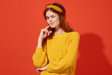 pretty emotional woman holding her hair Yellow sweater fashion red background