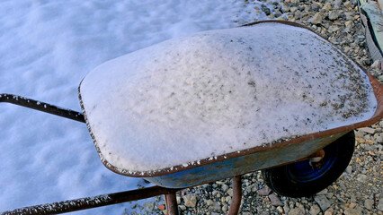 snow on a wheelbarrow in wintertime