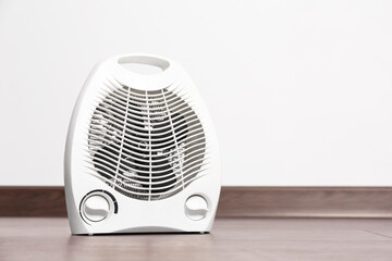 Fototapeta Modern electric fan heater on floor in room, space for text obraz