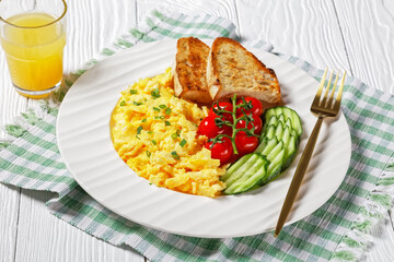 scrambled eggs with veggies and bread on a plate
