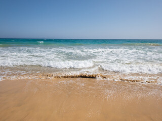 Fuerteventura, Spain - Atlantic ocean coast at Canary Islands with beautiful turquoise water. Hot sunny beach day. 