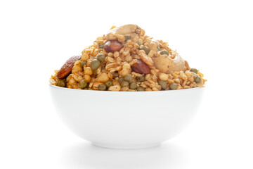 Shahi Mixture in a white ceramic bowl, made with peanut, cashew, corn flakes, almonds, etc. Pile of Indian spicy snacks (Namkeen). front view, against the white background