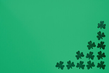 Concept of St. Patrick. Green clovers on green background, top view place for text